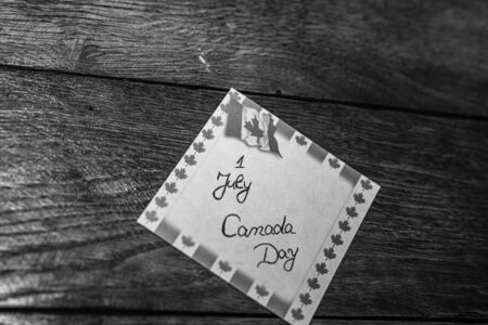 1 July, Canada day handwriting text on memo post reminder with Canada flag.のeditorial素材