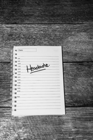 Headache, handwriting text on page of office agenda. Copy space.のeditorial素材