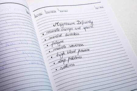 Magnesium deficiency symptoms, handwriting text on page of office agenda. Copy space.の写真素材