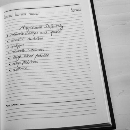 Magnesium deficiency symptoms, handwriting text on page of office agenda. Copy space.の写真素材