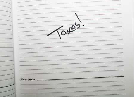 Taxes, handwriting text on page of office agenda. Copy space.の写真素材