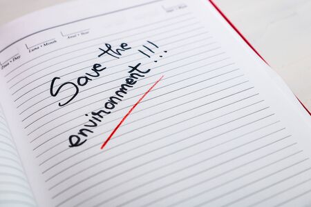 Save the environment, handwriting text on page of office agenda. Copy space.の写真素材