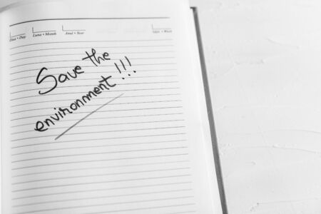 Save the environment, handwriting text on page of office agenda. Copy space.の写真素材