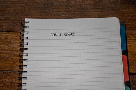 Daily report, handwriting text on page of office agenda, office spiral notebook. Copy space.の写真素材