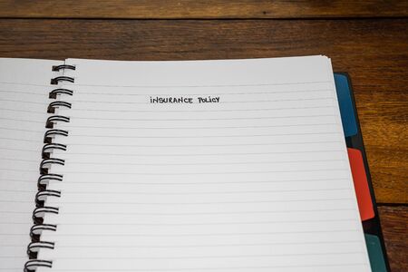 Insurance policy, handwriting text on page of office agenda, office spiral notebook. Copy space.の写真素材