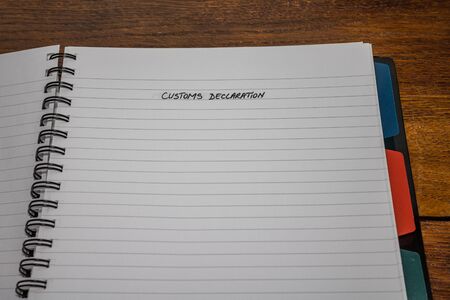 Customs declaration, handwriting text on page of office agenda, office spiral notebook. Copy space.の写真素材