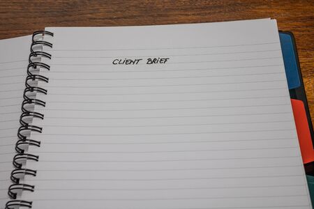 Client brief, handwriting text on page of office agenda, office spiral notebook. Copy space.の写真素材