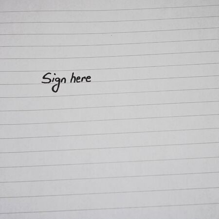 Sign here, handwriting text on page of office agenda, office spiral notebook. Copy space.の写真素材