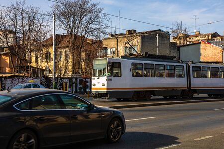 Car traffic at rush hour in downtown area. Tram in traffic. Bucharest, Romania, 2020.のeditorial素材