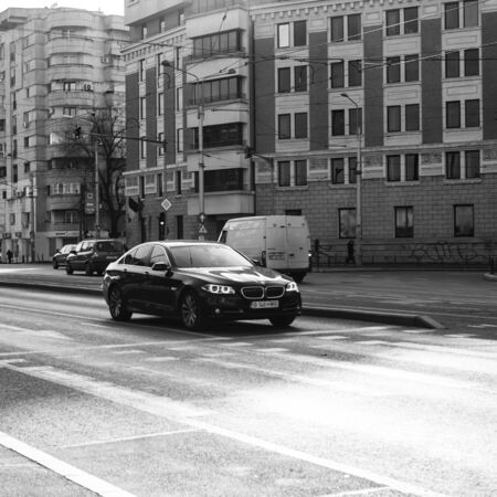 Car traffic at rush hour in downtown area. New BMW car waiting at traffic light. Bucharest, Romania, 2020.のeditorial素材