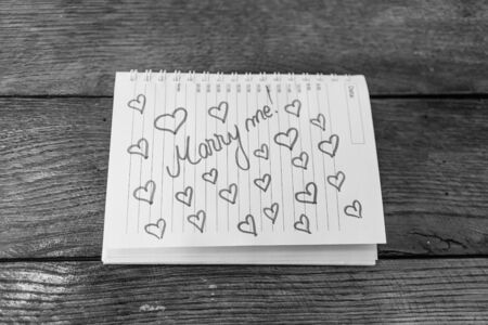 Marry me, writing love text on paper, lovely message. Text on spiral agenda. Romantic, love concept. Valentine`s day.の写真素材