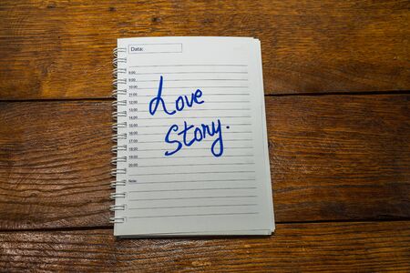 Love story, writing love text on paper, lovely message. Text on spiral agenda. Romantic, love concept. Valentine`s day.の写真素材