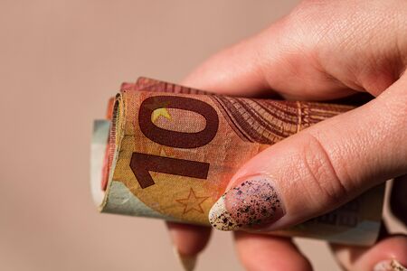 Man hands giving money like a bribe or tips. Holding EURO banknotes on a blurred background, EU currencyの写真素材