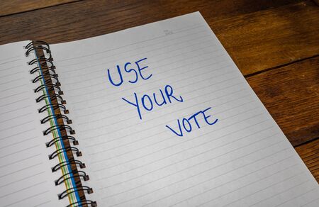 Use your vote, handwriting  text on paper, political message. Political text on office agenda. Concept of democracy, voting, politics. Copy space.の写真素材