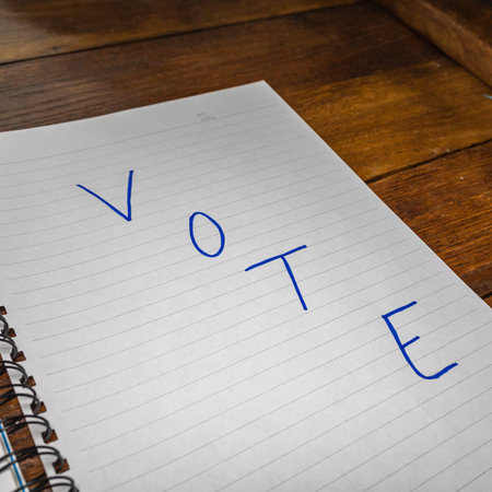 Vote, handwriting  text on paper, political message. Political text on office agenda. Concept of...