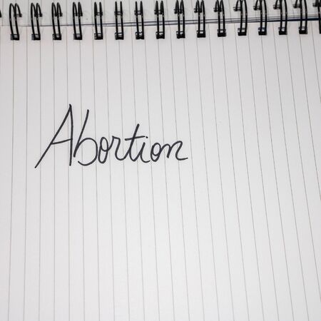 Abortion handwriting  text on paper, on office agenda. Copy space.の写真素材