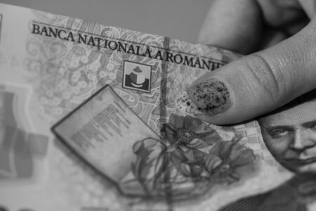 Woman hand giving money like bribe or tips isolated . LEI currency banknotes close up. Reward for hard work, finance and business conceptの写真素材