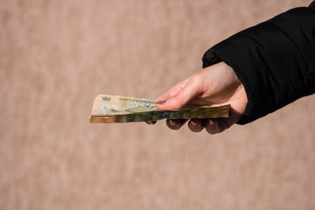 Woman hand giving money like bribe or tips isolated . LEI currency banknotes close up. Reward for...