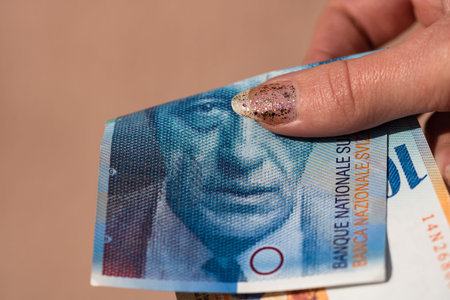World money concept, close up of 100 swiss franc banknote, photo of CHF currency isolated. Hand...