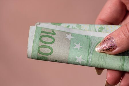 woman hands giving money like a bribe or tips. Holding EURO banknotes on a blurred background, EU currencyのeditorial素材