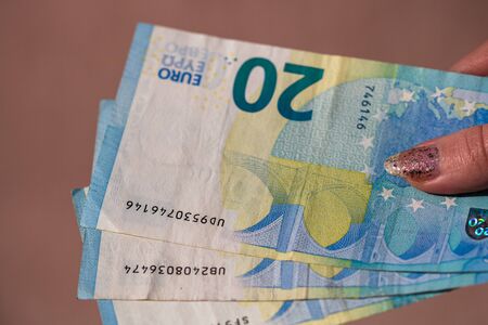 woman hands giving money like a bribe or tips. Holding EURO banknotes on a blurred background, EU currencyのeditorial素材