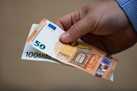 hands giving money like a bribe or tips. Holding EURO banknotes on a blurred background, EU currencyのeditorial素材