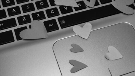 Heart shaped paper cut out on keyboard, love message and Valentine`s day concept.のeditorial素材