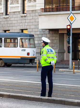 Police agent, Romanian Traffic Police (Politia Rutiera) directing traffic during the morning rush hour in downtown Bucharest, Romania, 2020のeditorial素材