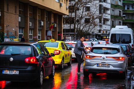 Car traffic at rush hour on the main boulevard in Bucharest downtown. Rainy morning, rainy evening during winter in Bucharest, Romania, 2020のeditorial素材