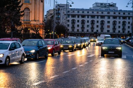 Car traffic at rush hour on the main boulevard in Bucharest downtown. Rainy morning, rainy evening during winter in Bucharest, Romania, 2020のeditorial素材