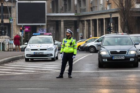 Police agent, Romanian Traffic Police (Politia Rutiera) directing traffic during the morning rush hour in downtown Bucharest, Romania, 2020のeditorial素材
