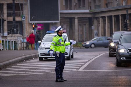 Police agent, Romanian Traffic Police (Politia Rutiera) directing traffic during the morning rush hour in downtown Bucharest, Romania, 2020のeditorial素材