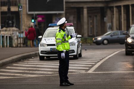 Police agent, Romanian Traffic Police (Politia Rutiera) directing traffic during the morning rush hour in downtown Bucharest, Romania, 2020のeditorial素材