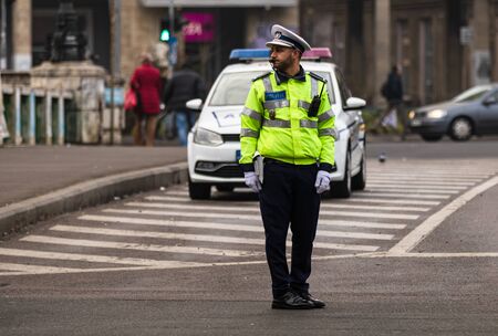 Police agent, Romanian Traffic Police (Politia Rutiera) directing traffic during the morning rush hour in downtown Bucharest, Romania, 2020のeditorial素材