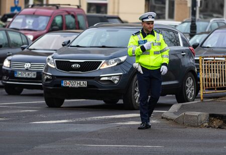Police agent, Romanian Traffic Police (Politia Rutiera) directing traffic during the morning rush hour in downtown Bucharest, Romania, 2020のeditorial素材