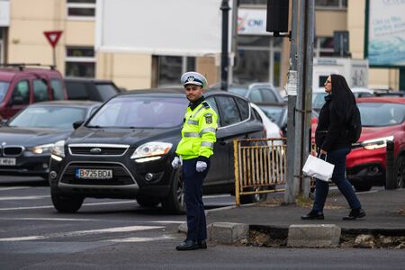 Police agent, Romanian Traffic Police (Politia Rutiera) directing traffic during the morning rush hour in downtown Bucharest, Romania, 2020のeditorial素材