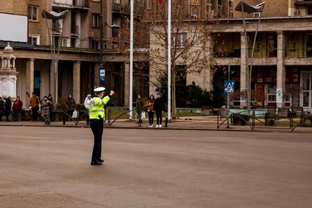 Police agent, Romanian Traffic Police (Politia Rutiera) directing traffic during the morning rush hour in downtown Bucharest, Romania, 2020のeditorial素材
