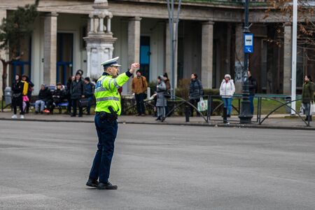 Police agent, Romanian Traffic Police (Politia Rutiera) directing traffic during the morning rush hour in downtown Bucharest, Romania, 2020のeditorial素材
