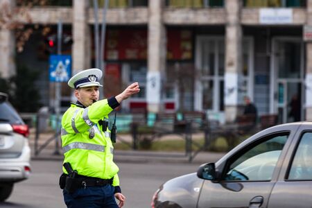Police agent, Romanian Traffic Police (Politia Rutiera) directing traffic during the morning rush hour in downtown Bucharest, Romania, 2020のeditorial素材