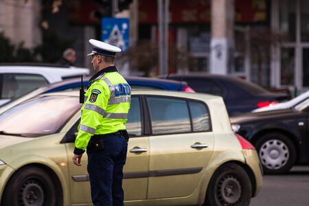 Police agent, Romanian Traffic Police (Politia Rutiera) directing traffic during the morning rush hour in downtown Bucharest, Romania, 2020のeditorial素材