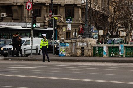 Police agent, Romanian Traffic Police (Politia Rutiera) directing traffic during the morning rush hour in downtown Bucharest, Romania, 2020のeditorial素材