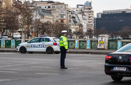 Police agent, Romanian Traffic Police (Politia Rutiera) directing traffic during the morning rush hour in downtown Bucharest, Romania, 2020のeditorial素材