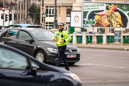 Police agent, Romanian Traffic Police (Politia Rutiera) directing traffic during the morning rush hour in downtown Bucharest, Romania, 2020のeditorial素材