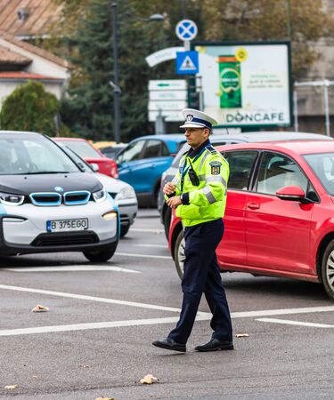 Police agent, Romanian Traffic Police (Politia Rutiera) directing traffic during the morning rush hour in downtown Bucharest, Romania, 2020のeditorial素材