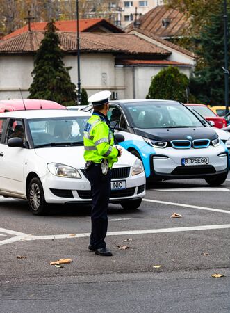 Police agent, Romanian Traffic Police (Politia Rutiera) directing traffic during the morning rush hour in downtown Bucharest, Romania, 2020のeditorial素材