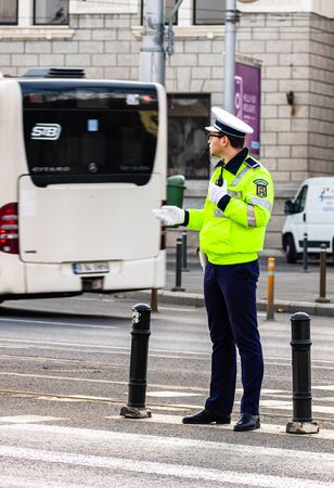 Police agent, Romanian Traffic Police (Politia Rutiera) directing traffic during the morning rush hour in downtown Bucharest, Romania, 2020のeditorial素材