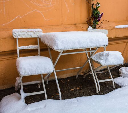 Perfectly shaped snow on table and chairs, covered with snow.の写真素材