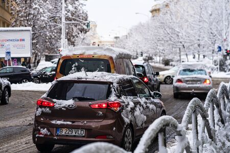 Snow on cars in the morning. Winter season and icy cars on the road in morning rush hour traffic of Bucharest, Romania, 2020のeditorial素材