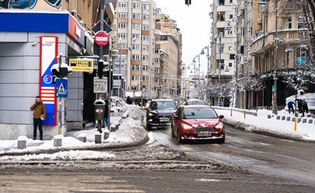 Snow on cars in the morning. Winter season and icy cars on the road in morning rush hour traffic of Bucharest, Romania, 2020のeditorial素材