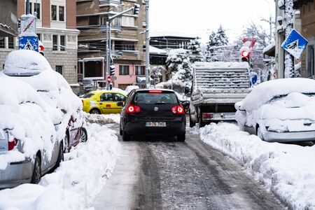 Snow on cars in the morning. Winter season and icy cars on the road in morning rush hour traffic of Bucharest, Romania, 2020のeditorial素材